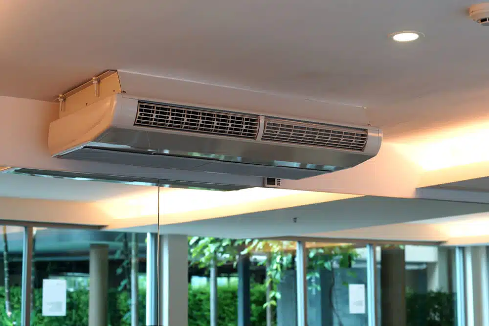 Aire acondicionado tipo cassette instalado en techo de espacio comercial en Medellín, diseño moderno con iluminación empotrada.